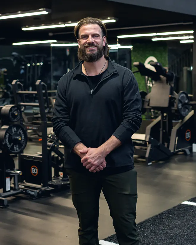 Aaron Buat, kinesiologist, standing on the training floor of a Kelowna gym.